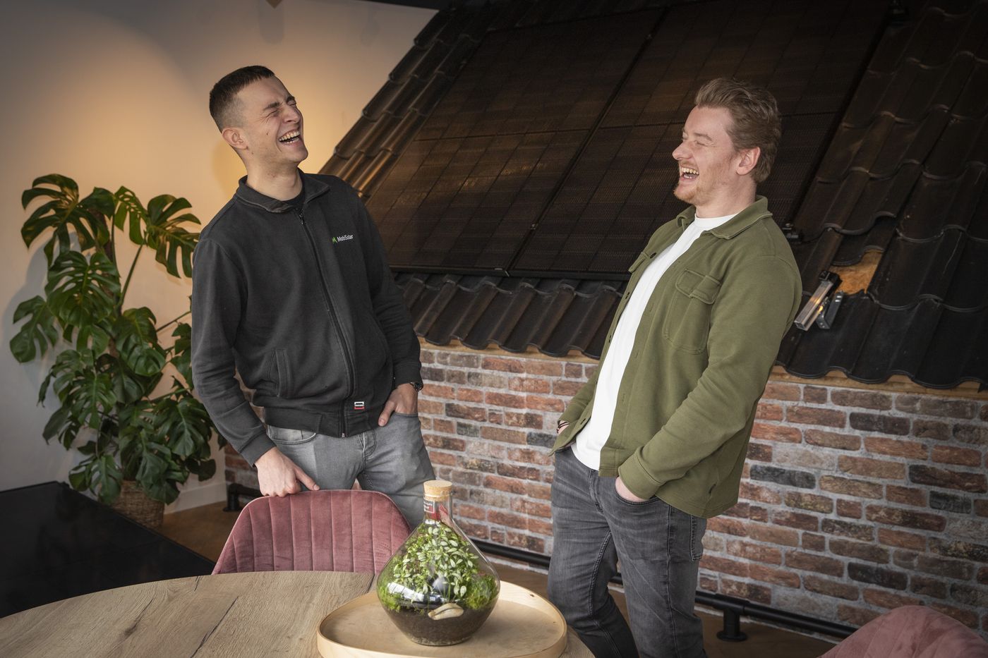 Niels lachend met een collega op kantoor